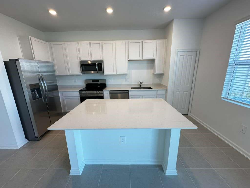 2729 Skyline Loop Kissimmee, FL 34758 - Photo 2 of 20 a kitchen with a refrigerator a stove a sink and a microwave