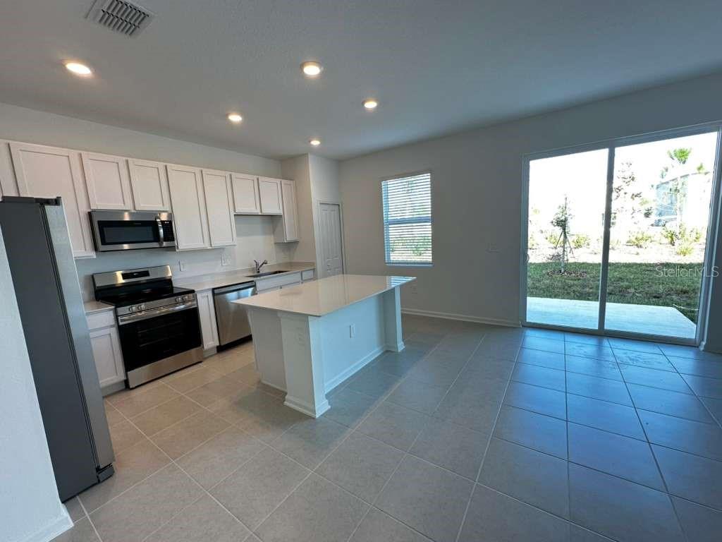 2729 Skyline Loop Kissimmee, FL 34758 - Photo 3 of 20 a kitchen with a sink a counter top space appliances and cabinets