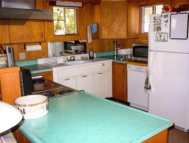 a kitchen with sink refrigerator and window