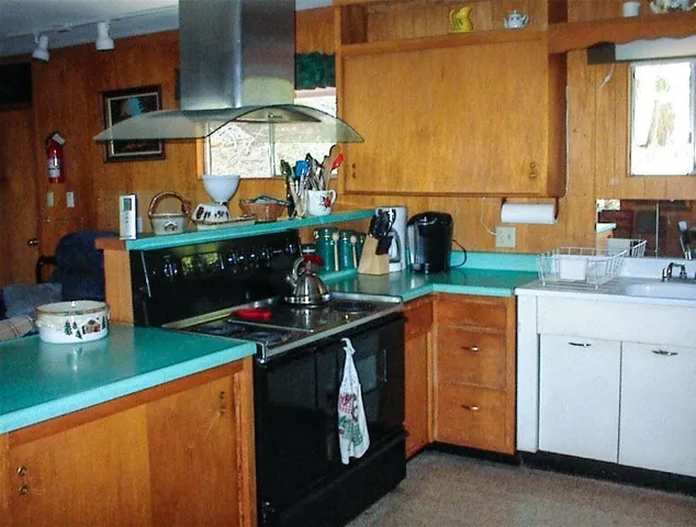 a kitchen with stainless steel appliances granite countertop a sink and a stove