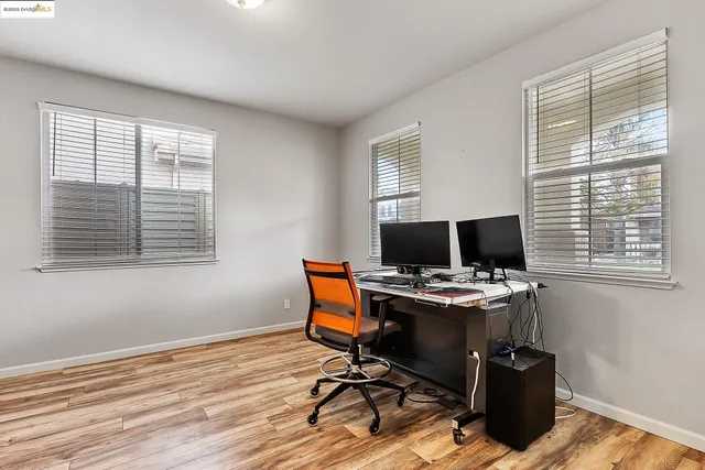 a view of a workspace with furniture and a window