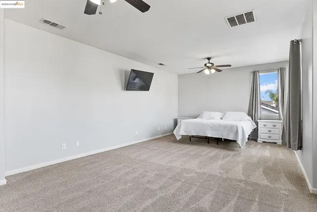a spacious bedroom with a bed and a chandelier