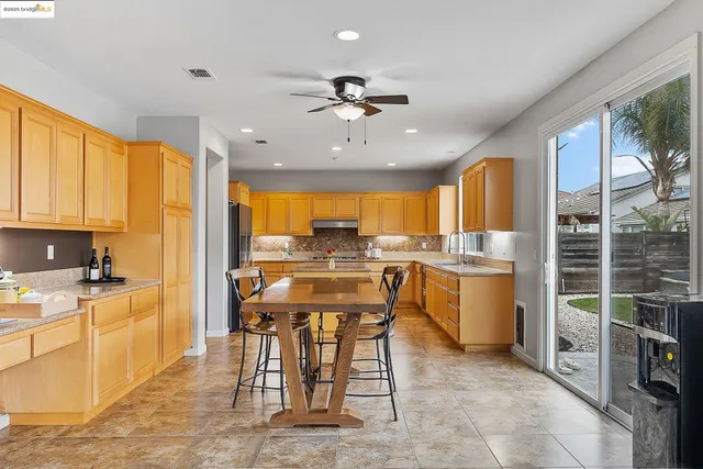 a kitchen with stainless steel appliances granite countertop a stove top oven a sink and a refrigerator