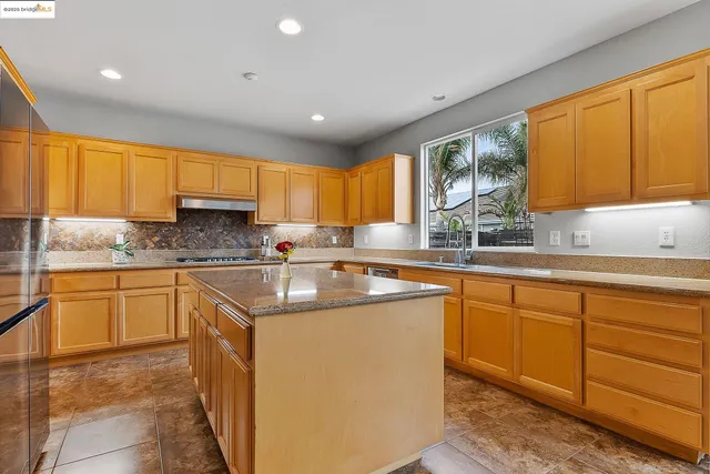 a dining hall with stainless steel appliances granite countertop a dining table and chairs