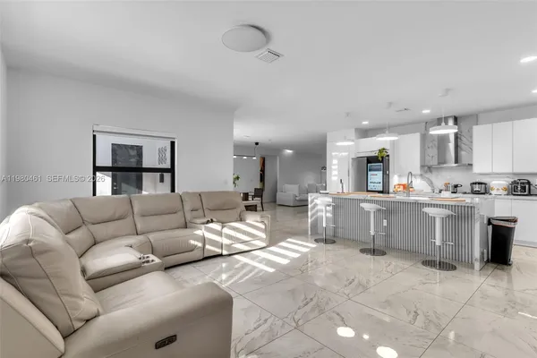 a living room with furniture and kitchen view