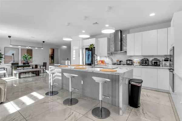 a kitchen with stainless steel appliances kitchen island granite countertop a table and chairs in it
