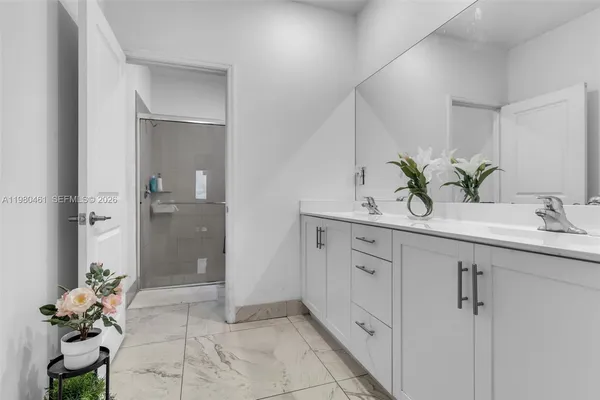 a bathroom with a sink mirror and a shower