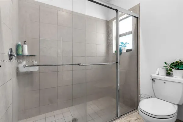 a bathroom with a toilet and a shower