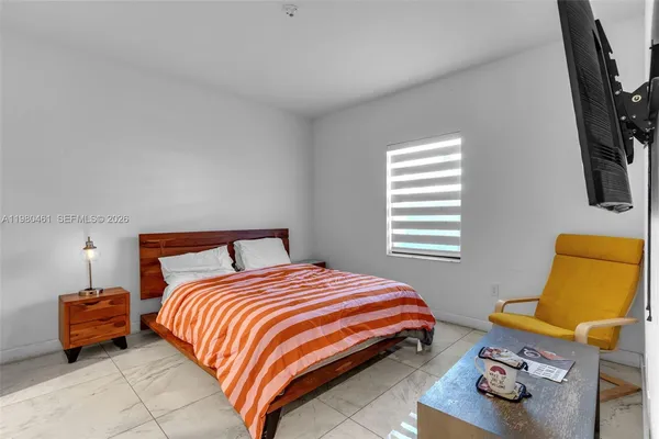 a bedroom with a bed and a flat screen tv