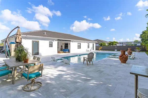 a view of a patio with table and chairs and potted plants