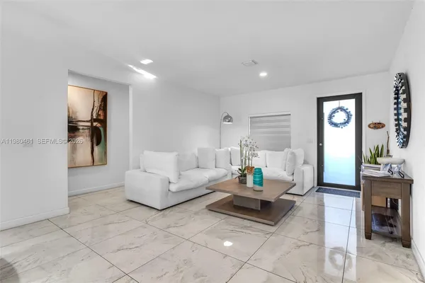 a living room with furniture and view of kitchen