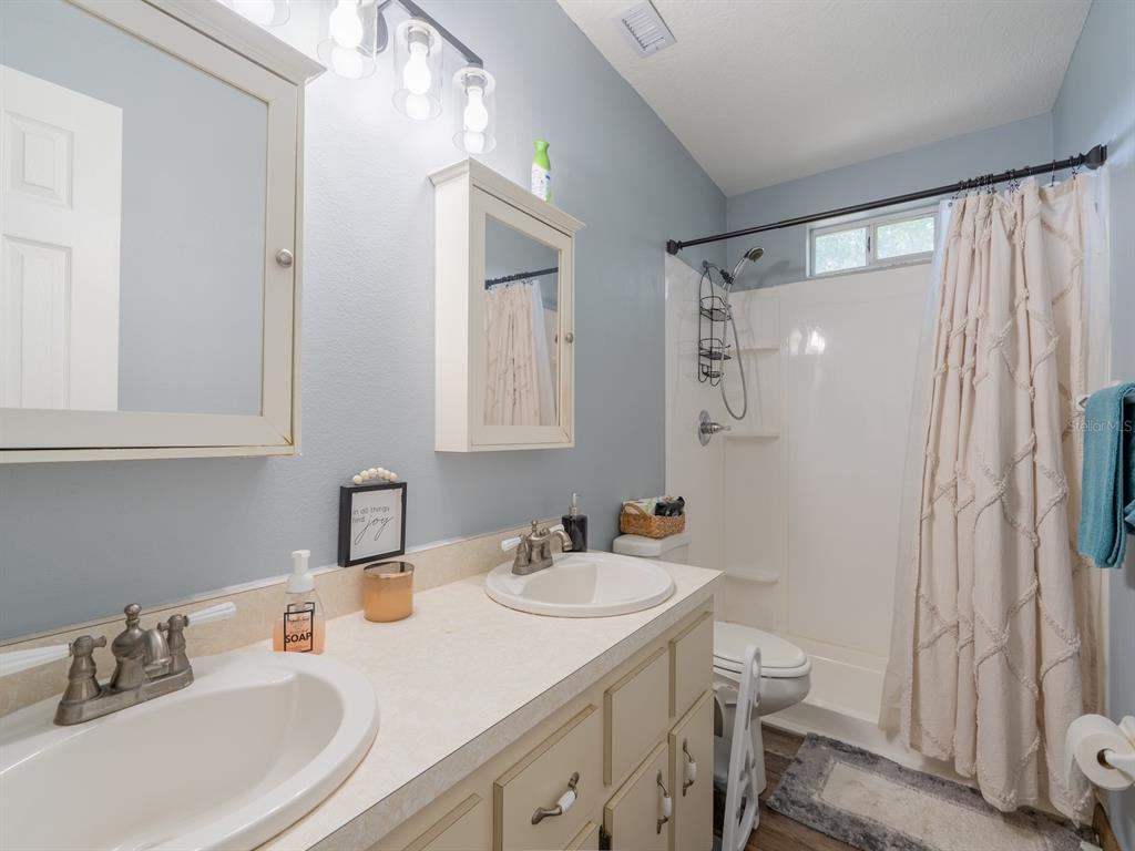 4381 Northeast 105th Place Anthony, FL 32617 - Photo 31 of 49 a bathroom with a sink toilet a mirror and shower