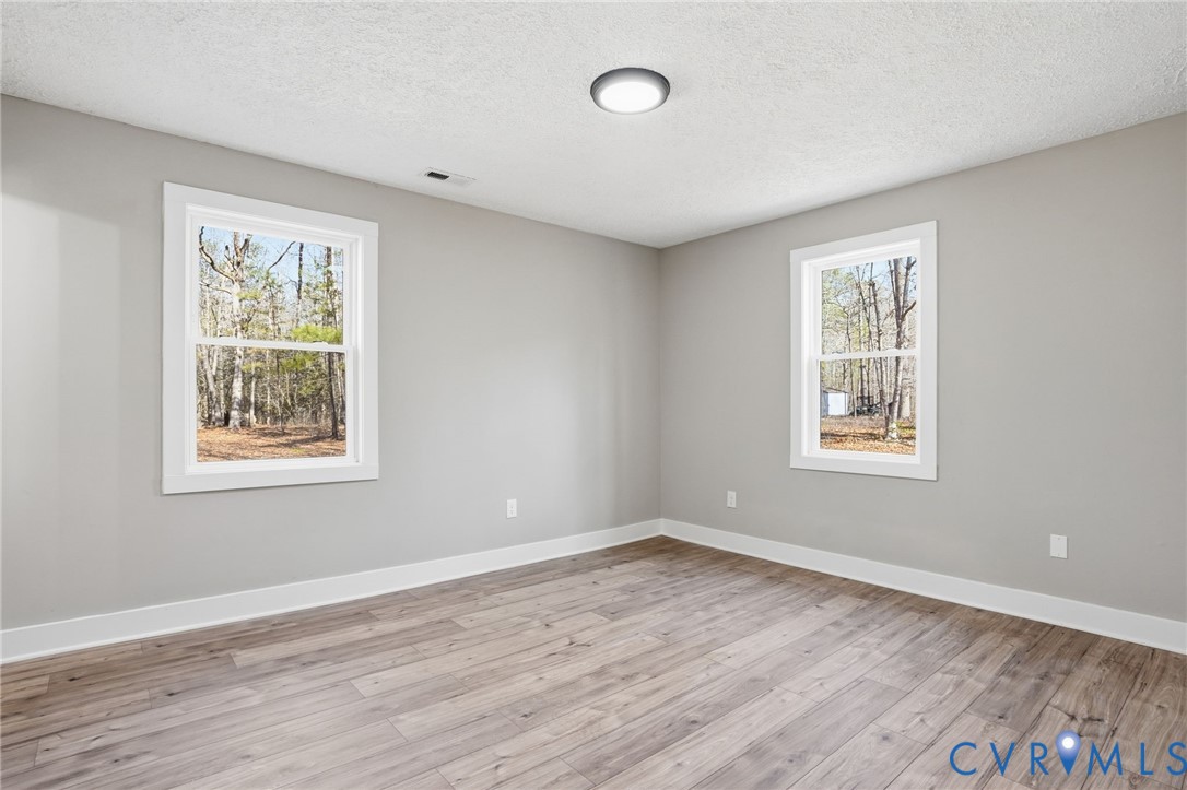 286 Mill Pond Road South St. Stephens Church, VA 23148 - Photo 13 of 39 a view of an empty room with wooden floor and a window