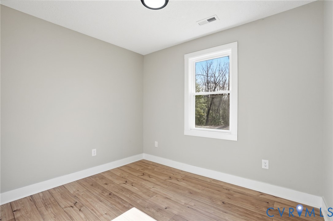 286 Mill Pond Road South St. Stephens Church, VA 23148 - Photo 14 of 39 a view of an empty room with wooden floor and a window