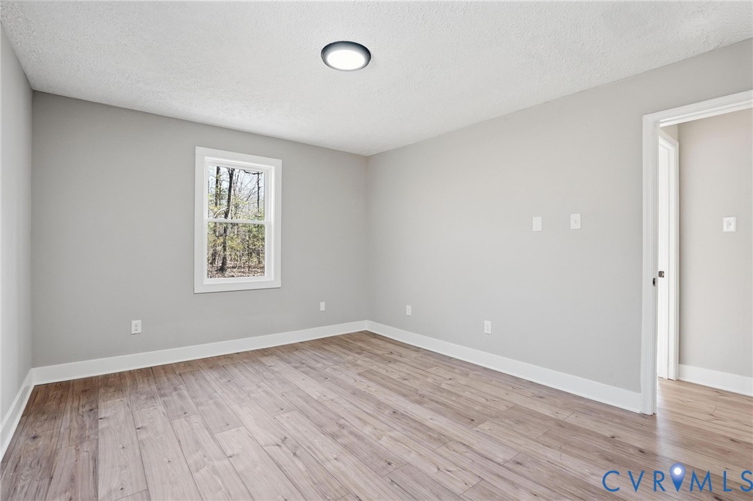 286 Mill Pond Road South St. Stephens Church, VA 23148 - Photo 15 of 39 an empty room with wooden floor and windows