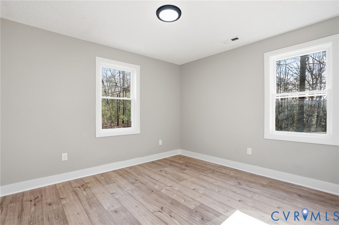 286 Mill Pond Road South St. Stephens Church, VA 23148 - Photo 18 of 39 an empty room with wooden floor and windows