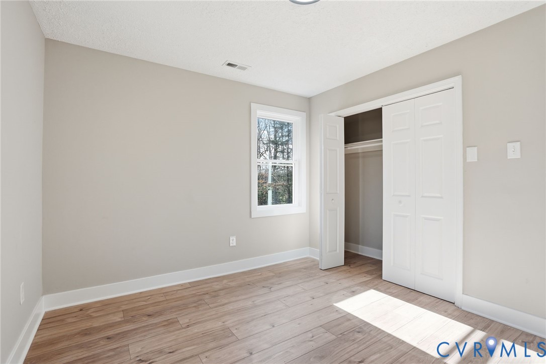 286 Mill Pond Road South St. Stephens Church, VA 23148 - Photo 19 of 39 an empty room with wooden floor and windows