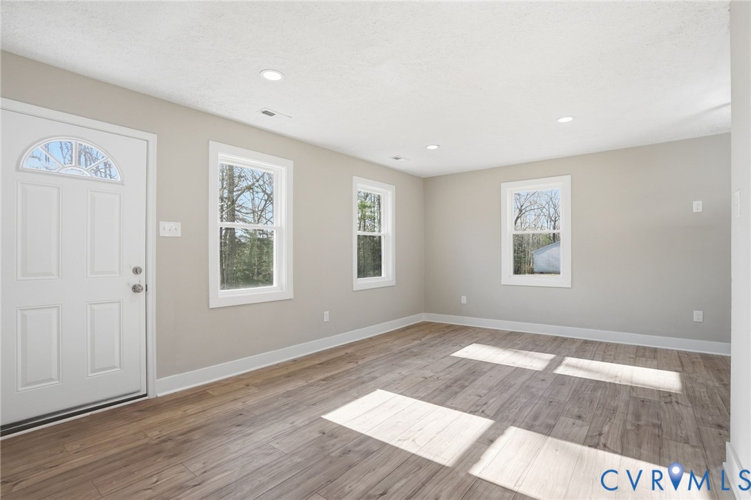 286 Mill Pond Road South St. Stephens Church, VA 23148 - Photo 2 of 39 a view of an empty room with window and wooden floor