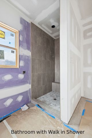 a spacious en suite bathroom with a tub shower and window