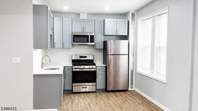 a kitchen with stainless steel appliances a refrigerator a stove a microwave and sink