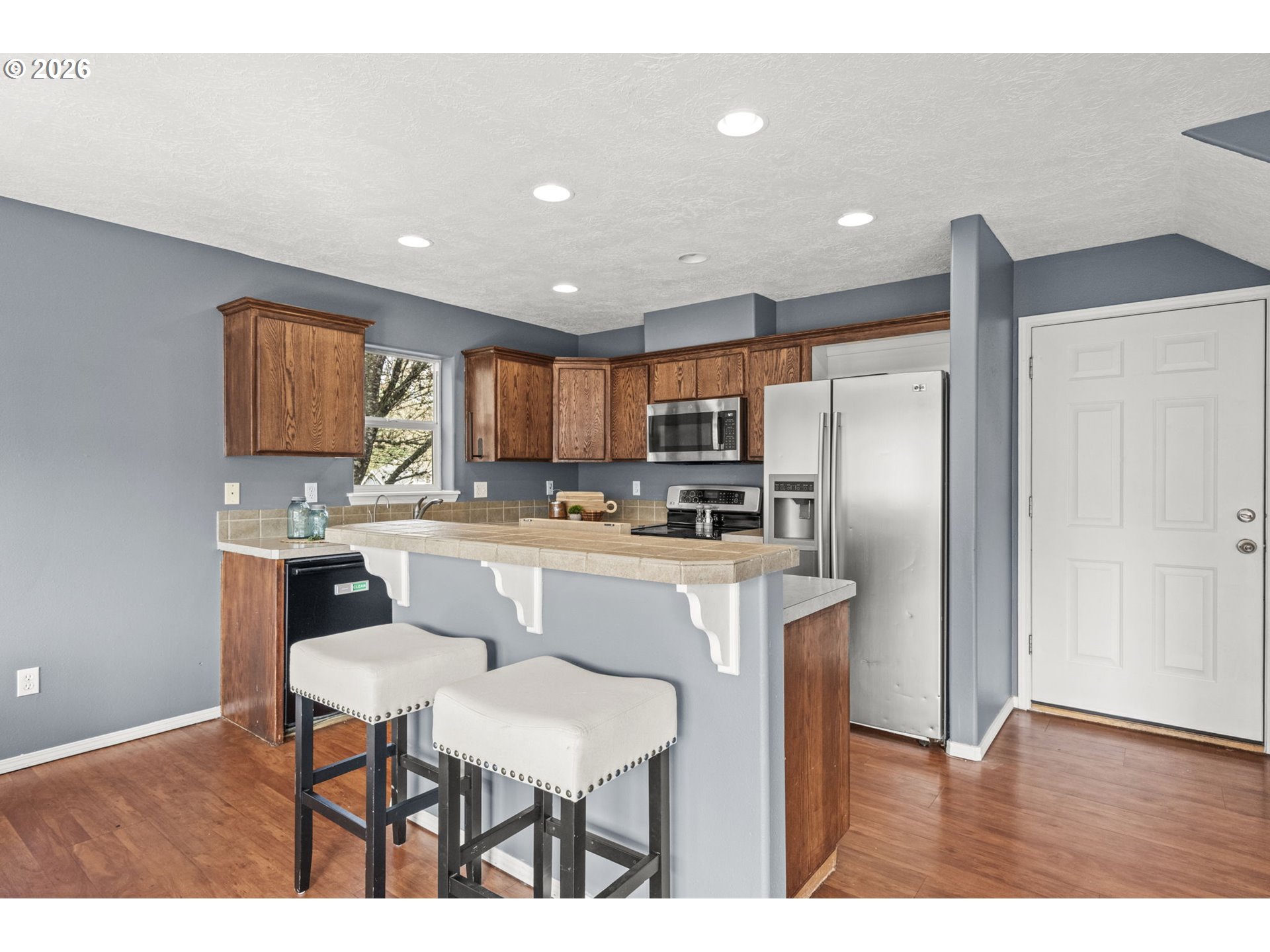 38882 Haskins Street Sandy, OR 97055 - Photo 15 of 46 a kitchen with refrigerator cabinets dining table and chairs