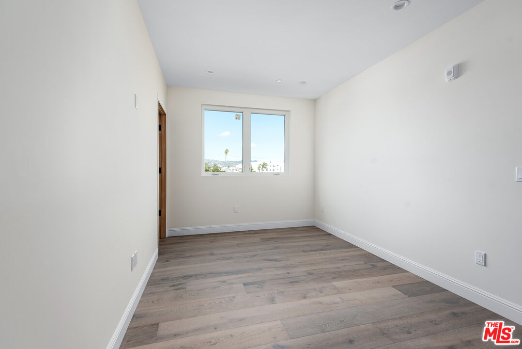 1429 South Bedford Street, Unit 201 Los Angeles, CA 90035 - Photo 11 of 12 an empty room with wooden floor and windows