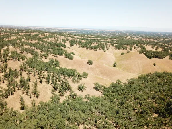 an aerial view of house with yard and mountain view in back
