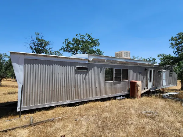 a view of a house with backyard and sitting area