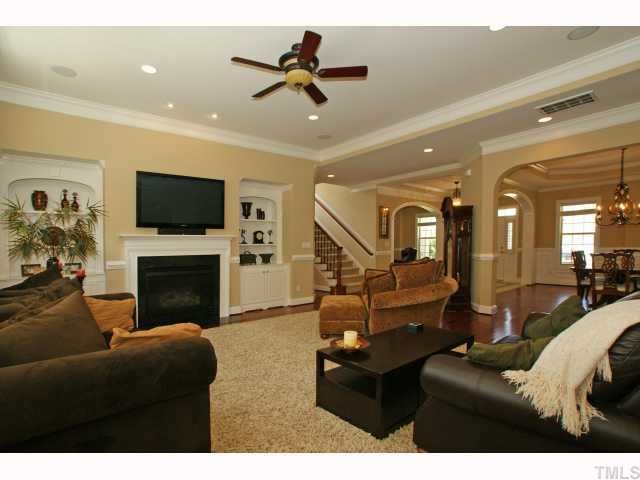 3921 Sunridge Road Raleigh, NC 27613 - Photo 5 of 12 a living room with furniture a fireplace and a flat screen tv
