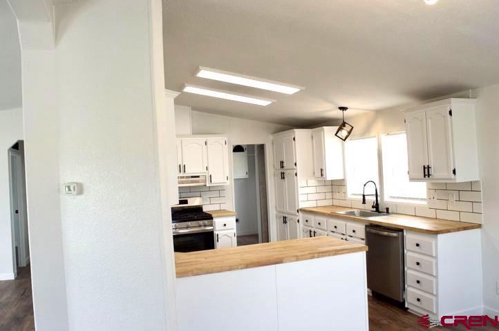 268 County Road Aa42 Frontage Road Norwood, CO 81423 - Photo 11 of 19 a kitchen with granite countertop a refrigerator stove top oven and sink