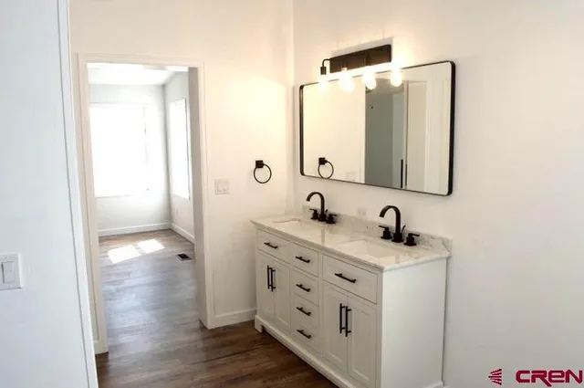 a bathroom with a double vanity sink mirror and bathtub