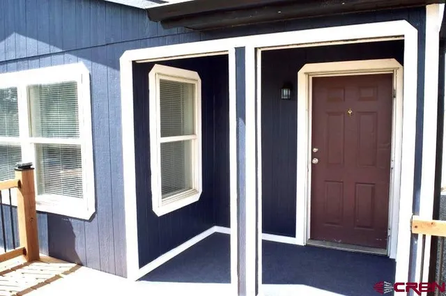 an empty room with wooden floor closet and windows