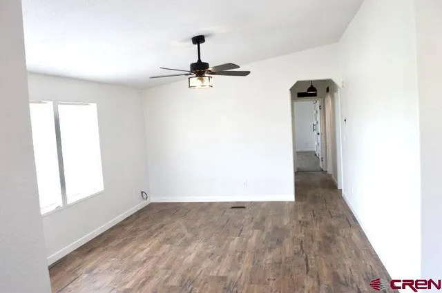 a view of an empty room and window with wooden floor