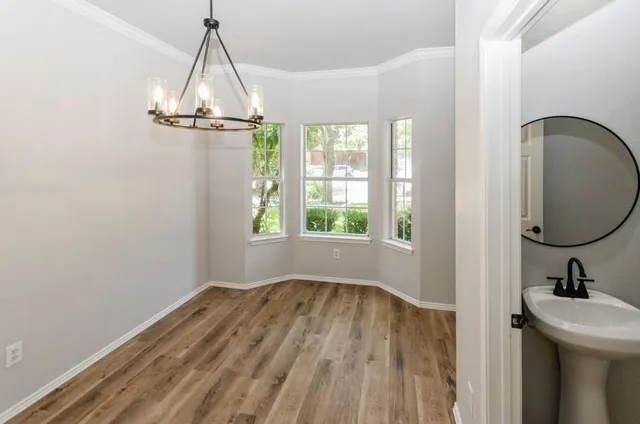 a view of a room with wooden floor fan and windows