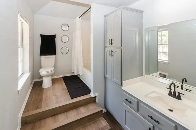 a bathroom with a sink a toilet and shower