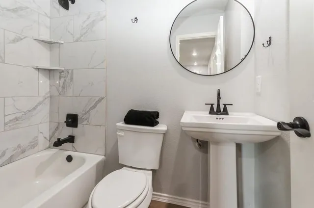 a bathroom with a sink a toilet and bathtub