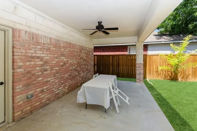 a balcony with table and chairs and potted plants with wooden floor
