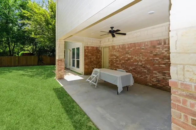 a view of a patio with a table and chairs with wooden fence