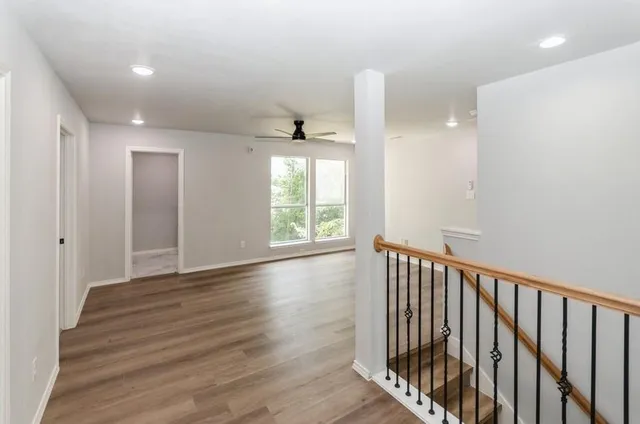 a view of a hallway with wooden floor and windows