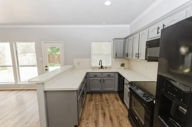 a kitchen with a sink a stove and cabinets