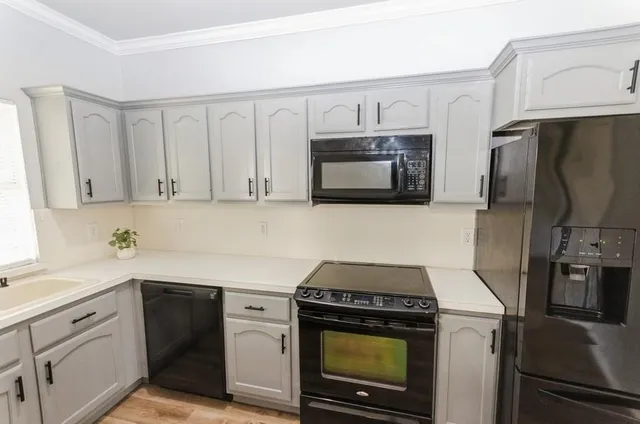 a kitchen with white cabinets stainless steel appliances and a sink
