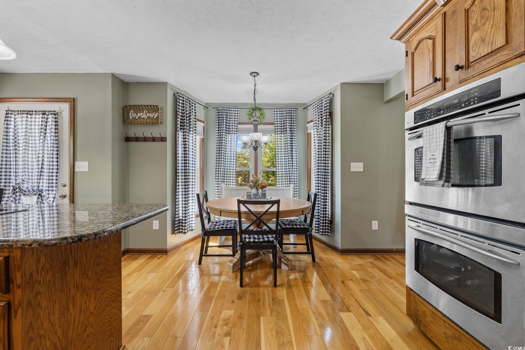 2731 Fork Of Swamp Road Galivants Ferry, SC 29544 - Photo 12 of 32 Dining area with a chandelier, wood flooring, and