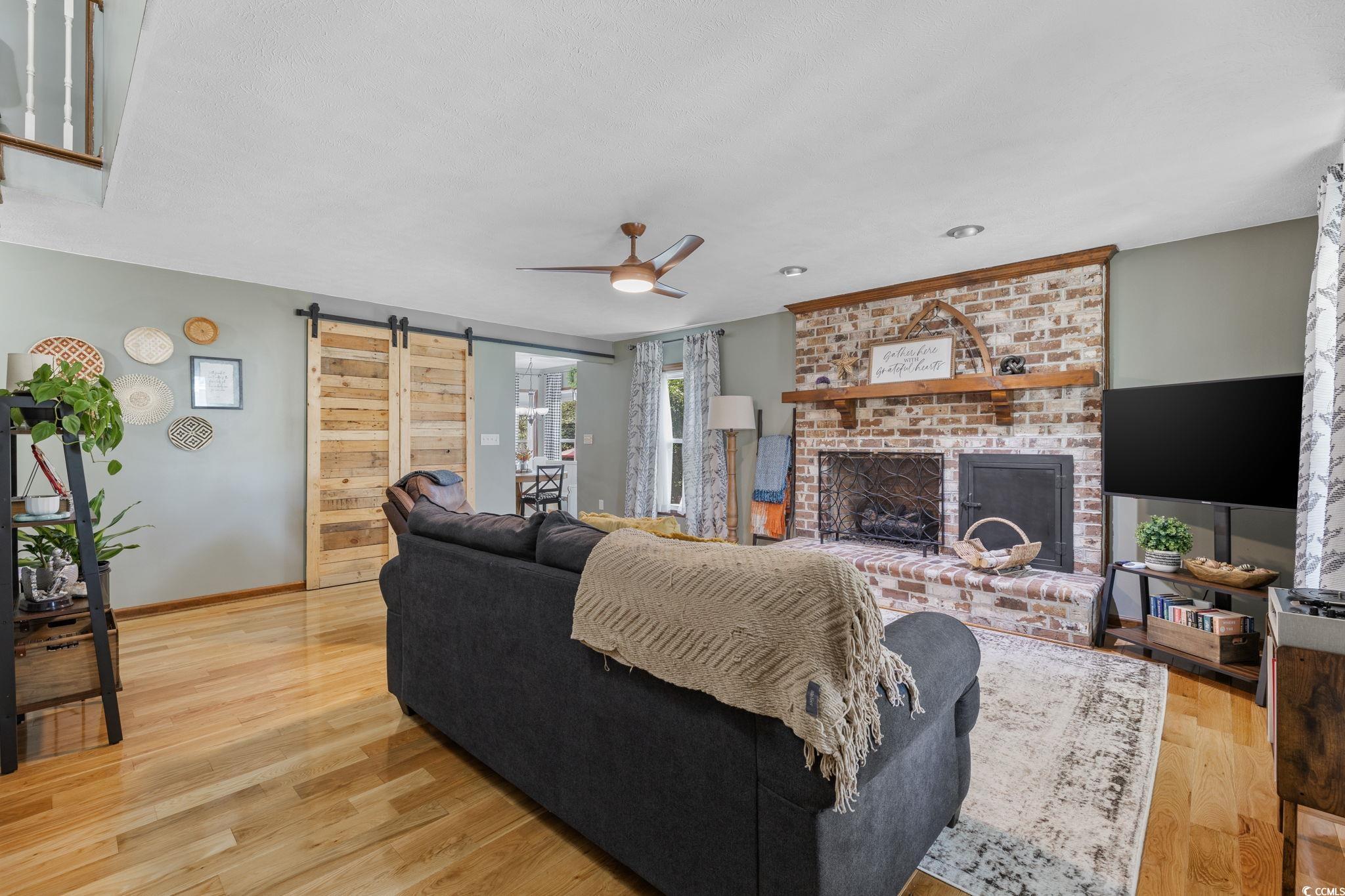 2731 Fork Of Swamp Road Galivants Ferry, SC 29544 - Photo 8 of 32 Living room with wood flooring, a barn door, a bri