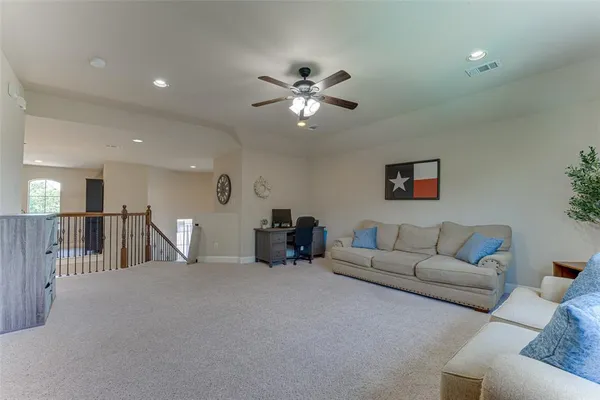 a living room with furniture and a ceiling fan