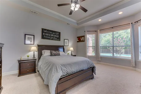 a bedroom with a large bed and a chandelier