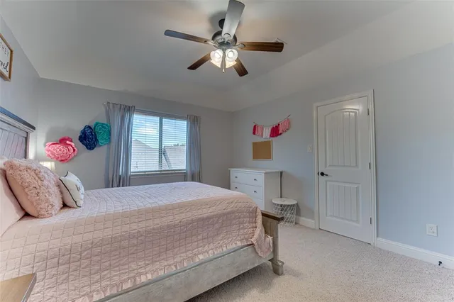 a bedroom with a bed chandelier and a window
