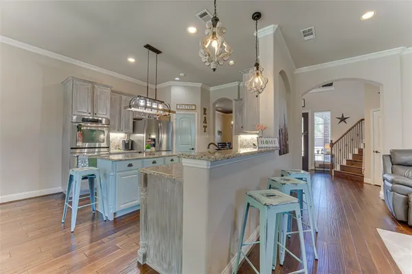 a kitchen with refrigerator cabinets dining table and chairs