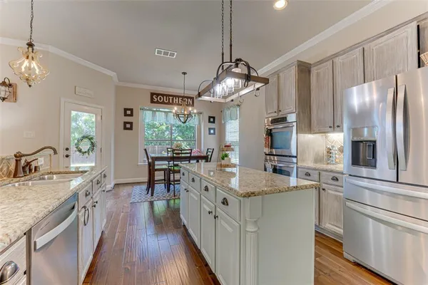 a kitchen with stainless steel appliances granite countertop a sink refrigerator and cabinets