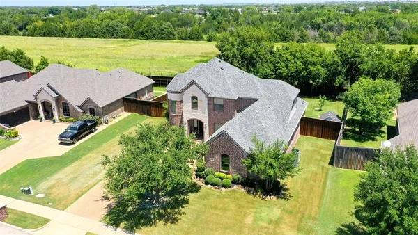 an aerial view of a house with swimming pool and garden
