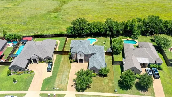 an aerial view of residential houses with outdoor space and swimming pool